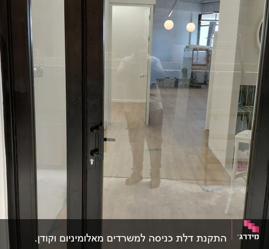 דלת זכוכית עם מסגרת אלומיניום בחדר פנימי